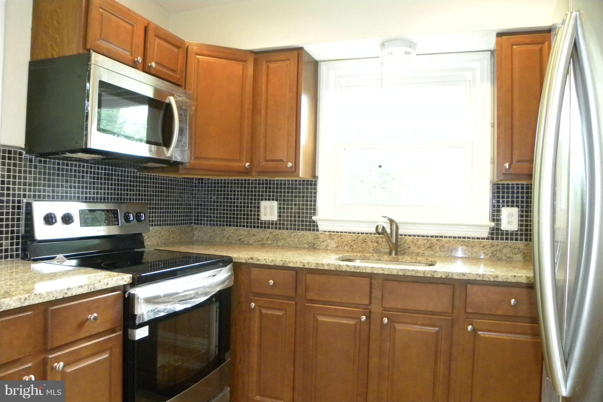 4140 Addison Road Fairfax, VA 22030 - Photo 5 of 27 a kitchen with granite countertop a sink a stove and a microwave