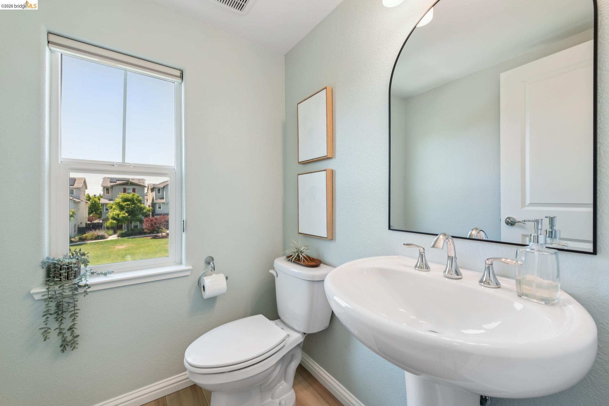24157 Amaranth Loop Hayward, CA 94541 - Photo 32 of 63 Pedestal sink with chrome fixtures and an arched mirror