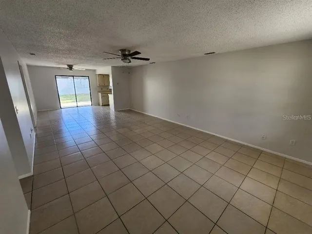 an empty room with windows and a ceiling fan