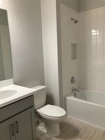 a bathroom with a white toilet sitting next to a white sink and vanity