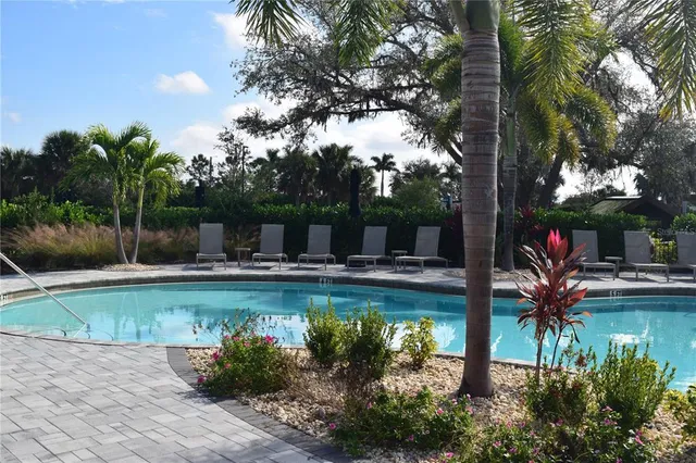 a view of a swimming pool with a table and chairs under an umbrella