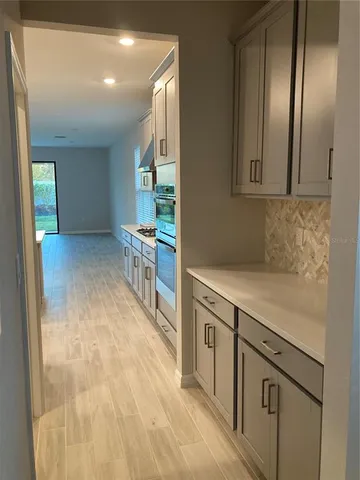 a view of a kitchen with furniture and wooden floor