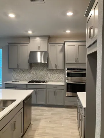a kitchen with kitchen island granite countertop a stove and a sink