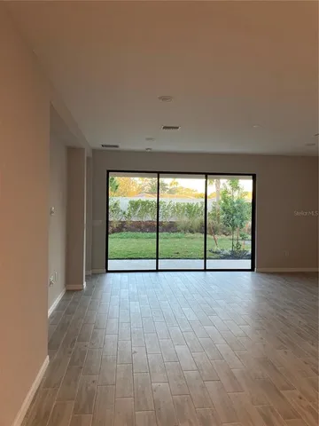 wooden view of an empty room with wooden floor and a floor to ceiling window