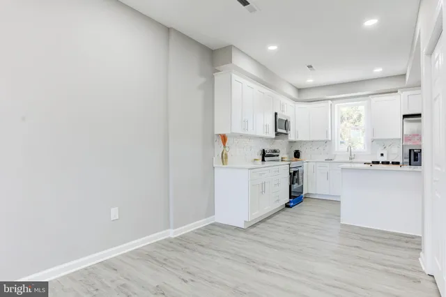 a kitchen with granite countertop white cabinets and white appliances