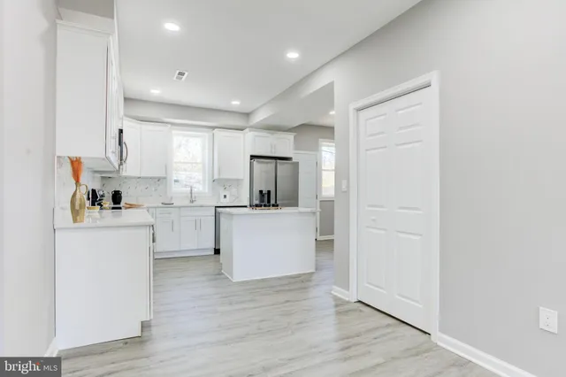a kitchen with white cabinets and refrigerator