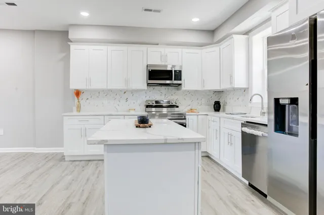 a kitchen with stainless steel appliances a microwave sink refrigerator and cabinets