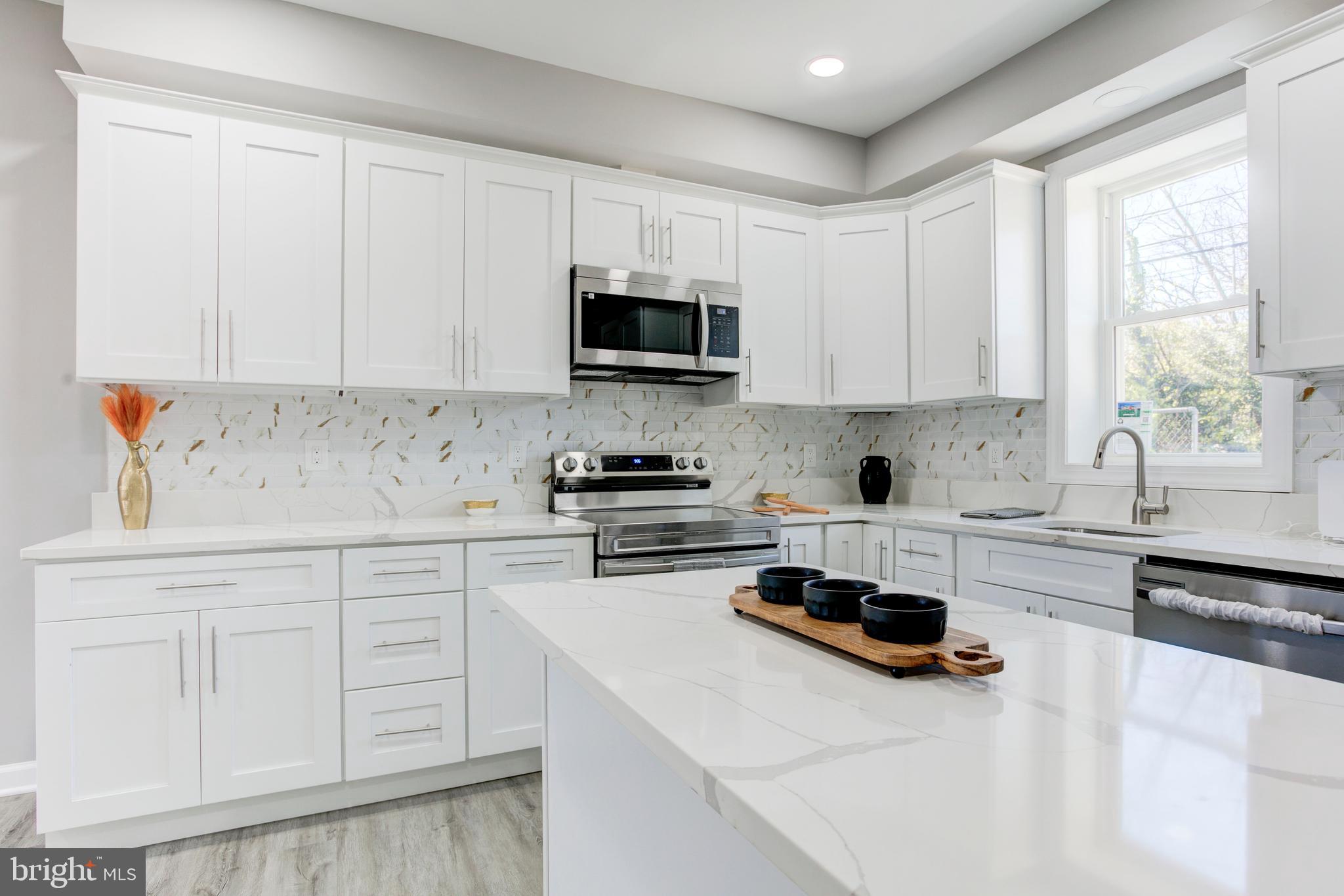 156 South Hilton Street Baltimore, MD 21229 - Photo 17 of 39 a kitchen with white cabinets and a stove top oven