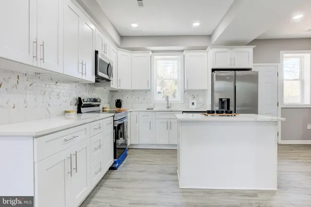 a kitchen with stainless steel appliances granite countertop a sink and cabinets