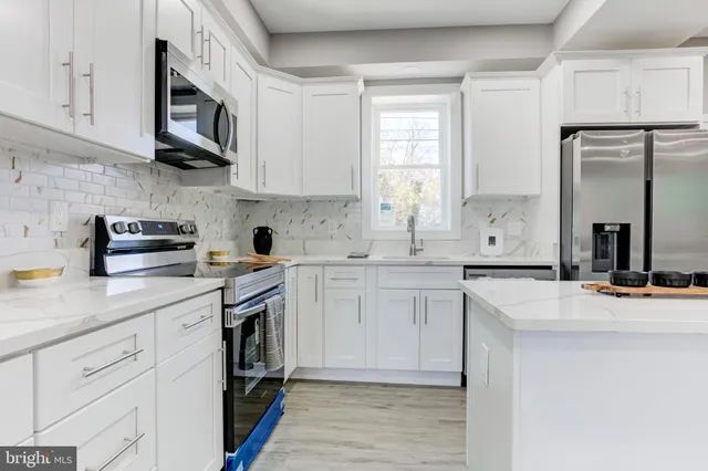 a kitchen with stainless steel appliances granite countertop a sink stove and cabinets