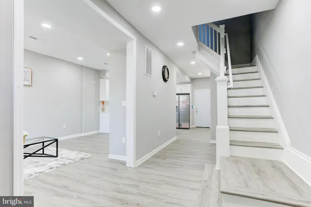a view of a hallway with wooden floor and entryway