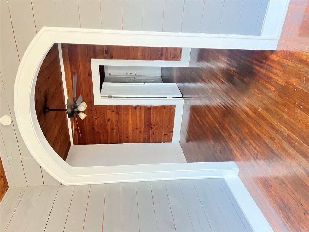 703 West 11th Street, Unit 5 Austin, TX 78701 - Photo 6 of 12 Unfurnished room featuring arched walkways, wooden walls, hardwood / wood-style flooring, a ceiling fan, and wooden ceiling