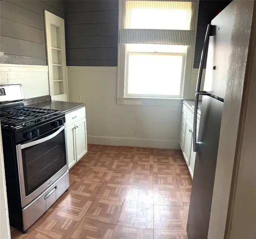 a kitchen with a stove a fridge and a window