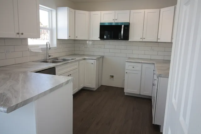 a kitchen with a sink and a stove top oven