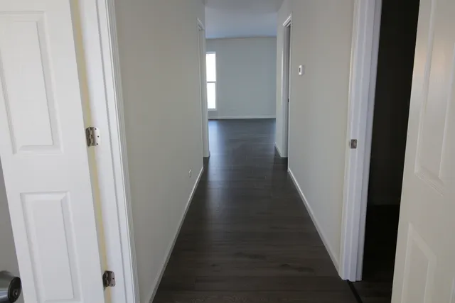 a view of a hallway with wooden floor