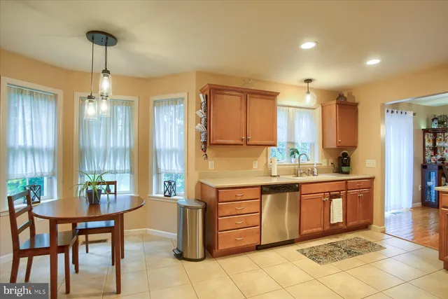 a large kitchen with kitchen island granite countertop a table and chairs in it