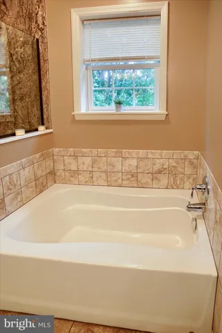a bathroom with bathtub and window