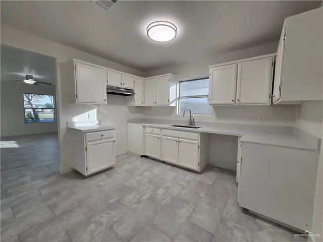 a kitchen with stainless steel appliances a sink stove and cabinets