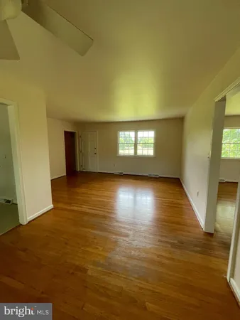 a view of empty room with window and wooden floor