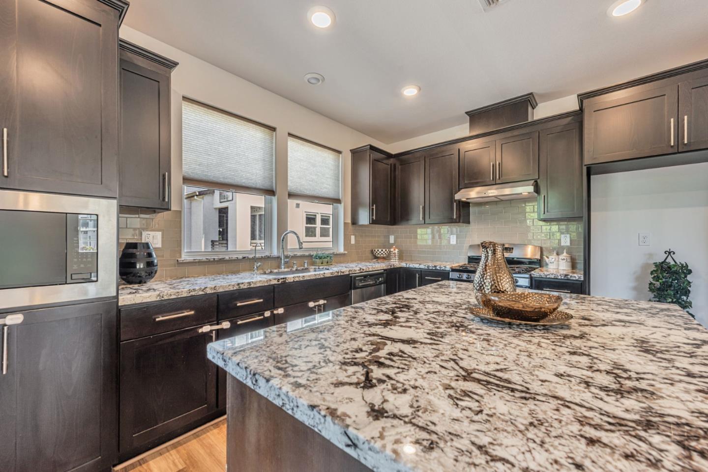 96 Zenith Common Fremont, CA 94539 - Photo 17 of 53 a kitchen with stainless steel appliances granite countertop a sink stove and refrigerator