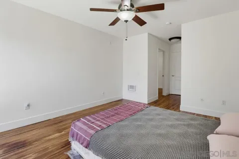 a bedroom with a bed and wooden floor