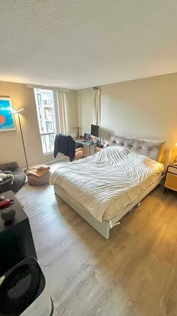 a bedroom with a bed a couch and a window