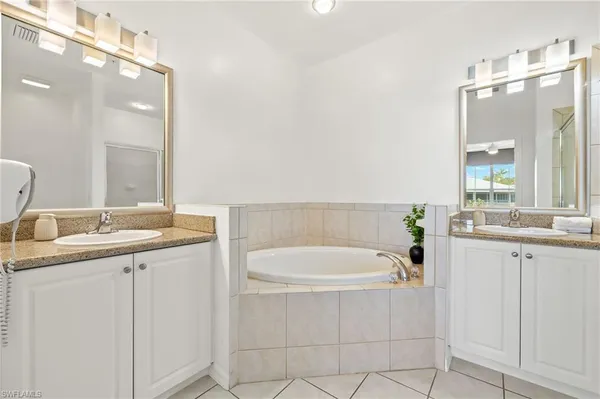 a bathroom with a granite countertop sink mirror and bathtub