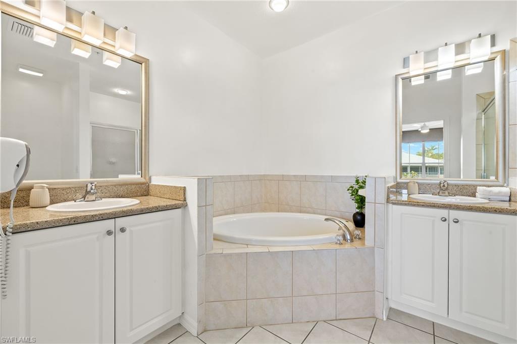 7940 Mahogany Run Lane, Unit 625 Naples, FL 34113 - Photo 11 of 30 a bathroom with a granite countertop sink mirror and bathtub