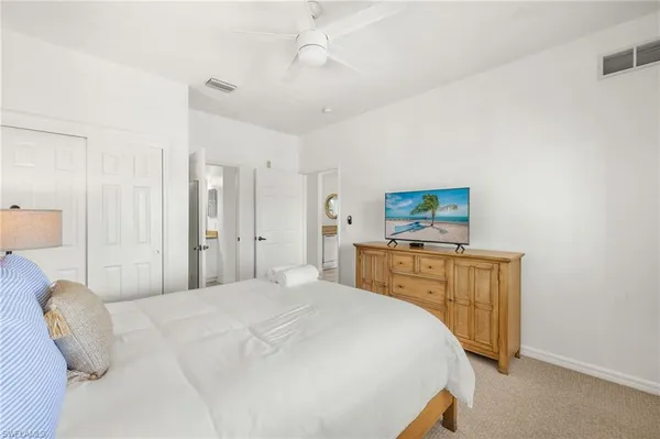 a bedroom with a bed and a flat tv screen on dresser