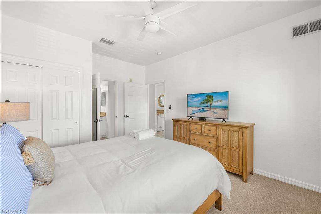 7940 Mahogany Run Lane, Unit 625 Naples, FL 34113 - Photo 13 of 30 a bedroom with a bed and a flat tv screen on dresser