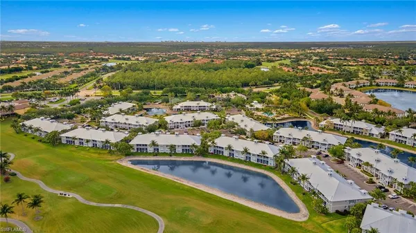 an aerial view of residential houses with outdoor space and lake view