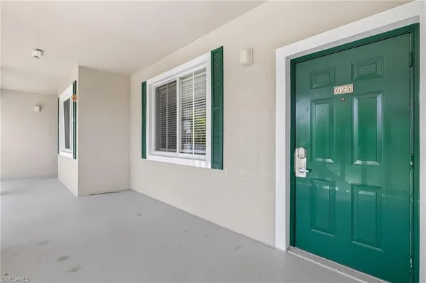 a view of an empty room with closet and entryway