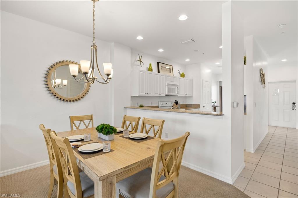 7940 Mahogany Run Lane, Unit 625 Naples, FL 34113 - Photo 4 of 30 a kitchen with stainless steel appliances granite countertop a dining table chairs and a refrigerator