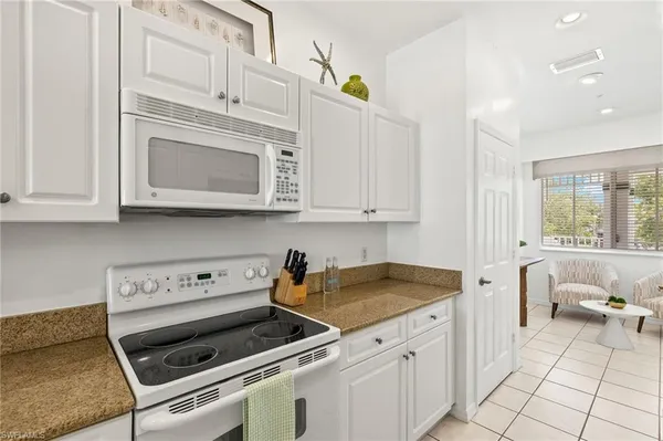 a kitchen with white cabinets and appliances