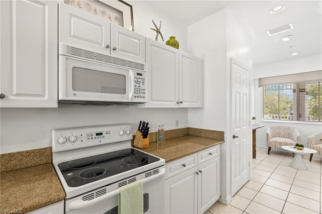 7940 Mahogany Run Lane, Unit 625 Naples, FL 34113 - Photo 8 of 30 a kitchen with white cabinets and appliances