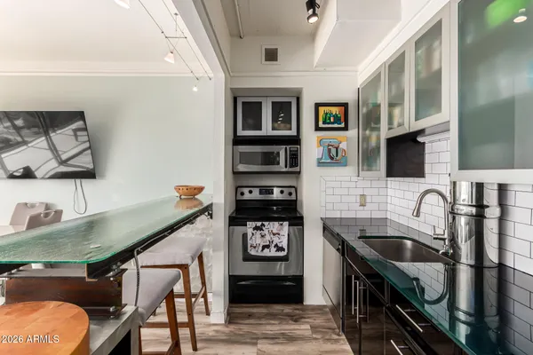 a kitchen with stainless steel appliances granite countertop a sink a stove and a refrigerator
