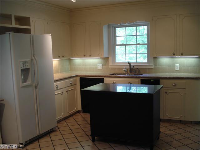 Kitchen. Granite countertops, tiled backsplash, portable island, corner cupboard, recent appliances.