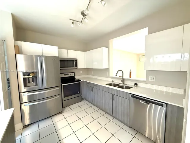 a kitchen with stainless steel appliances a sink and a refrigerator