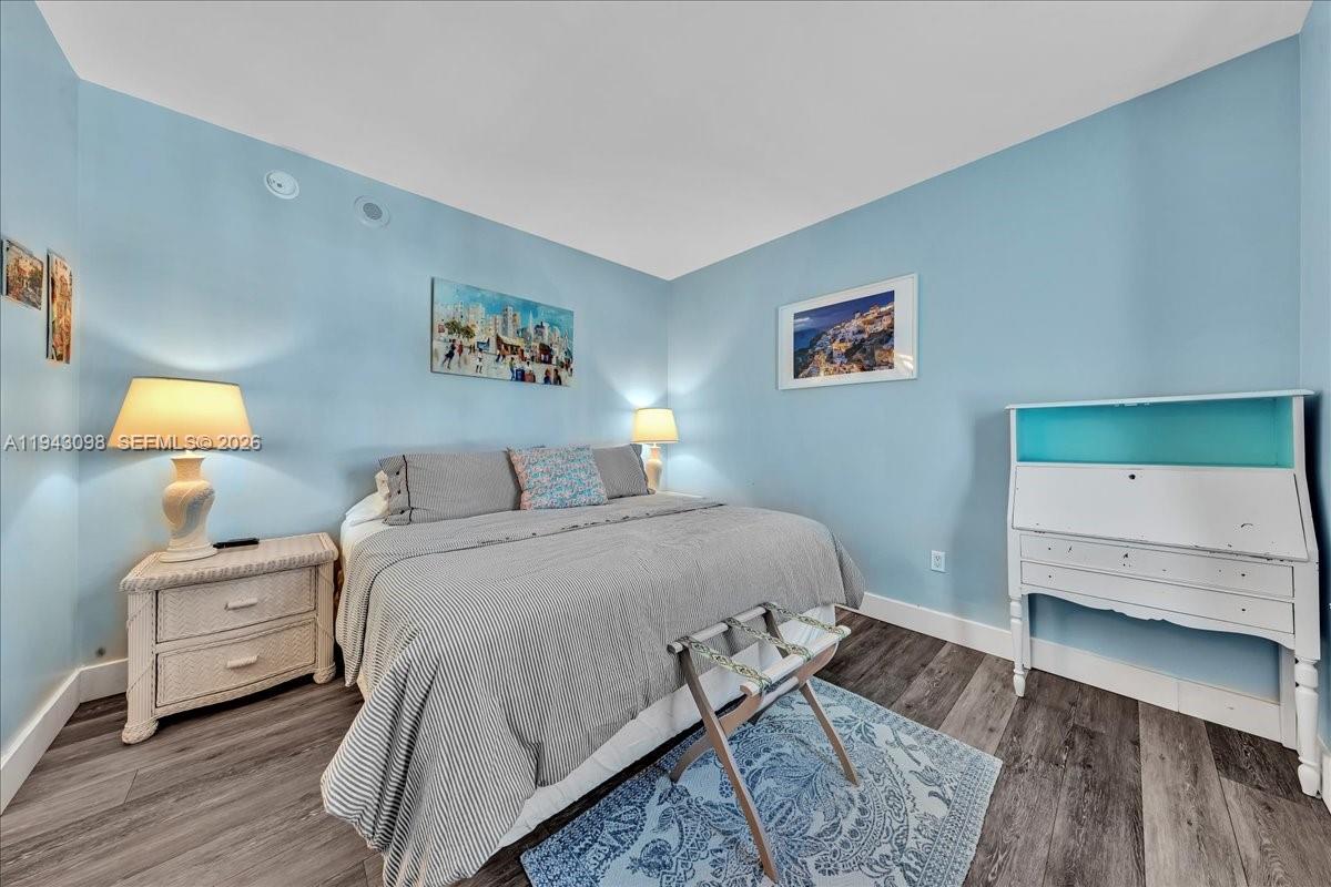 90 Southwest 3rd Street, Unit 2604 Miami, FL 33130 - Photo 33 of 59 a bedroom with a bed and wooden floor