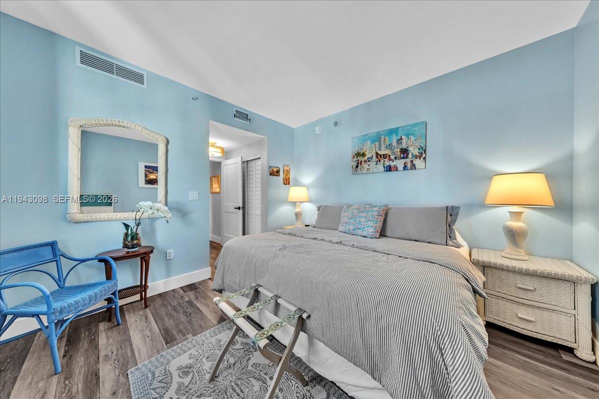 90 Southwest 3rd Street, Unit 2604 Miami, FL 33130 - Photo 34 of 59 a bedroom with a bed and wooden floor