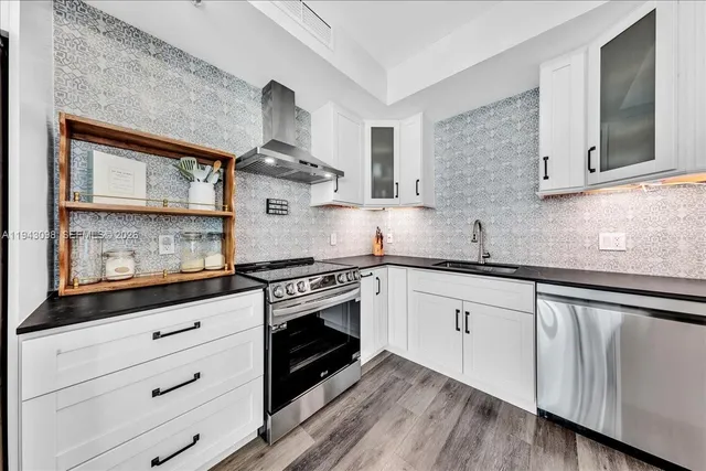 a kitchen with stainless steel appliances white cabinets and a sink