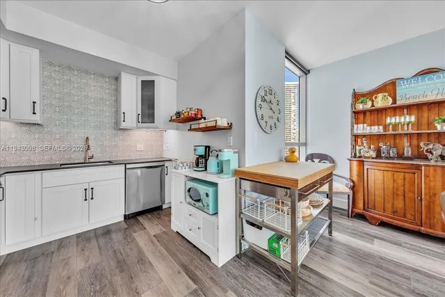 a kitchen with stainless steel appliances a stove cabinets and wooden floor