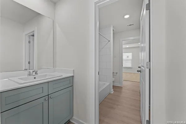a en suite bathroom with a granite countertop sink mirror and toilet