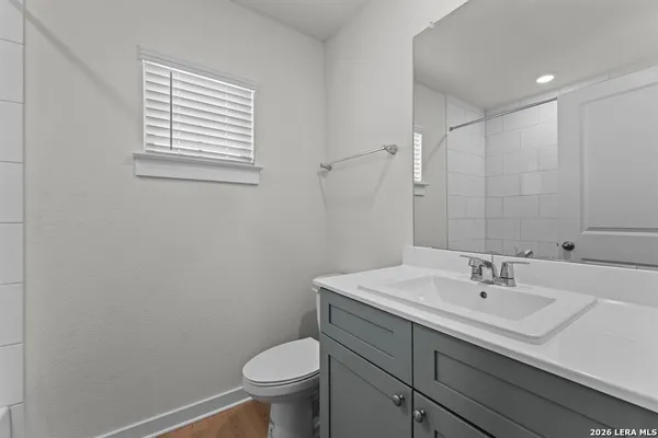 a bathroom with a sink a toilet and a mirror