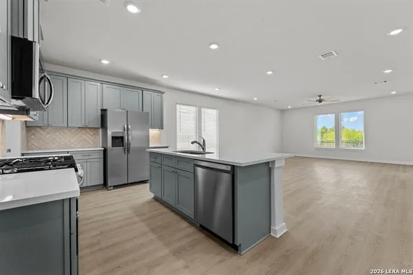 a kitchen with stainless steel appliances granite countertop a stove a sink and a refrigerator