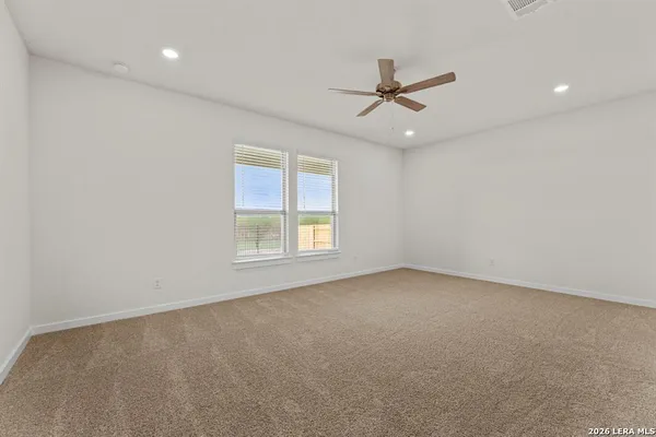 an empty room with a window and a fan