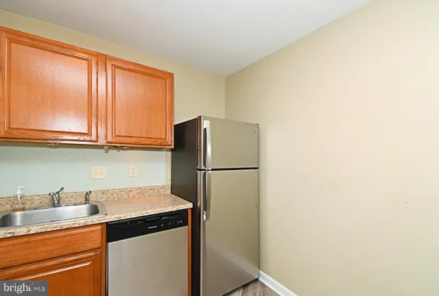 a kitchen with stainless steel appliances granite countertop a refrigerator a stove a sink and dishwasher