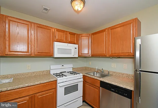a kitchen with granite countertop stainless steel appliances a stove a sink and a microwave