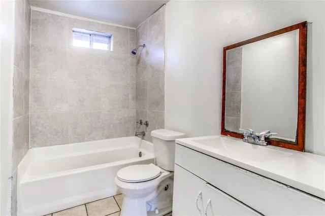 a bathroom with a sink a toilet a mirror and bathtub