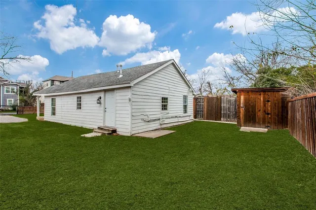 a view of a backyard with plants and large trees